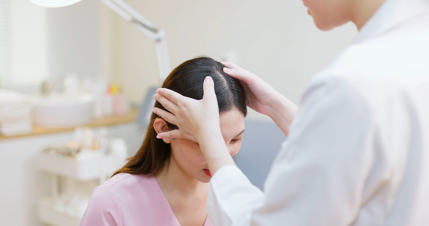 A dermatologist examines a patient's scalp for signs of dandruff or dry scalp.